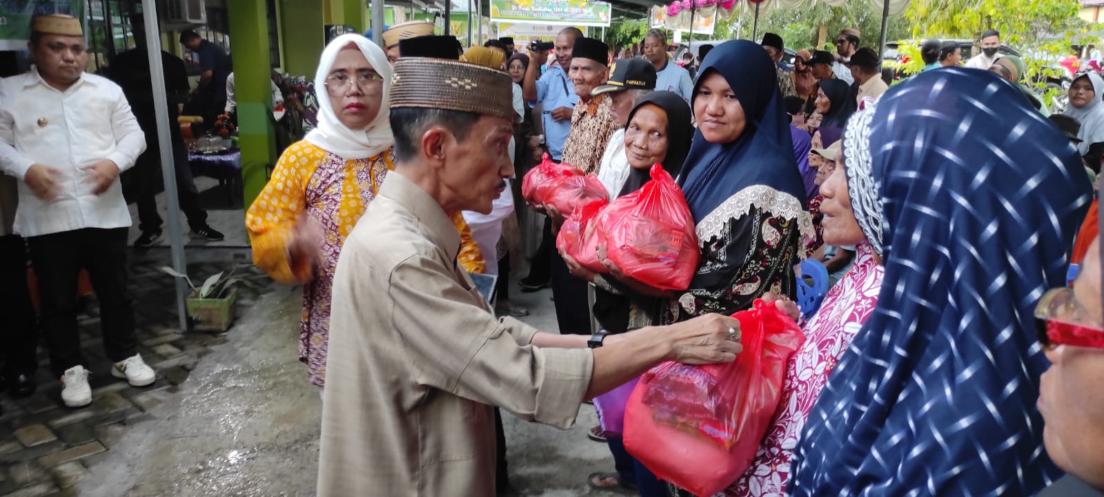 Bupati Kabupaten Gorontalo Prof.Dr Nelson Pomalingo didampingi pihak PT PG Gorontalo saat menyerahkan langsung secara simbolis kepada kaum Dhuafa paket Ramadan bantuan PT PG Gorontalo, di Kantor Camat Tolangohula, Senin (3/4/23). (Foto: Roy/Gorontalo Post).
